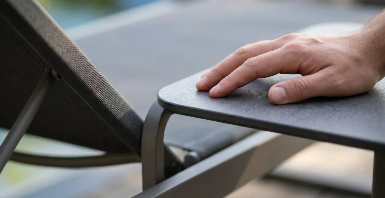 Vista macro de zona de alcance ergonómico desde tumbona reclinada con mesa auxiliar
