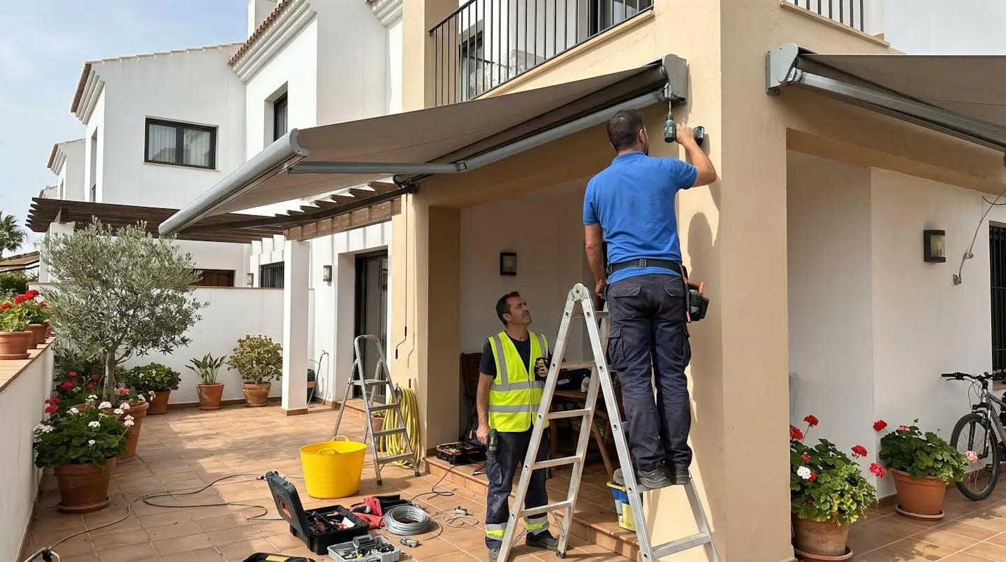 Técnico profesional visto de espaldas trabajando en la instalación de un toldo en entorno residencial español contemporáneo con herramientas y estructura visible